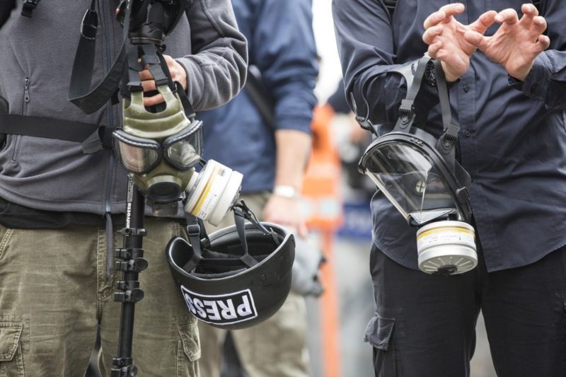 Des journalistes avec des masques à gaz